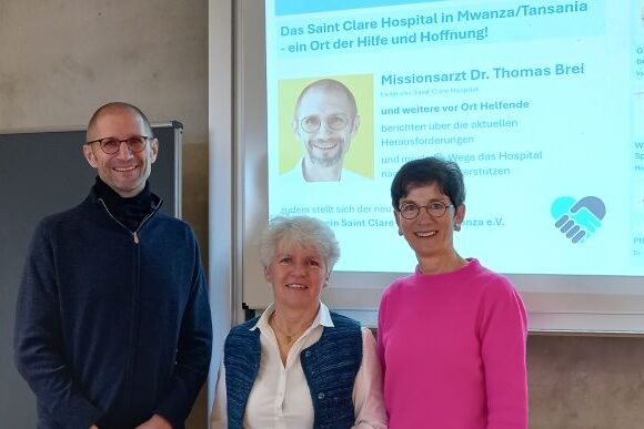 Gruppe_1_bearbeitet Eine Gruppe von Menschen, die vor einer Projektionsfläche stehen.