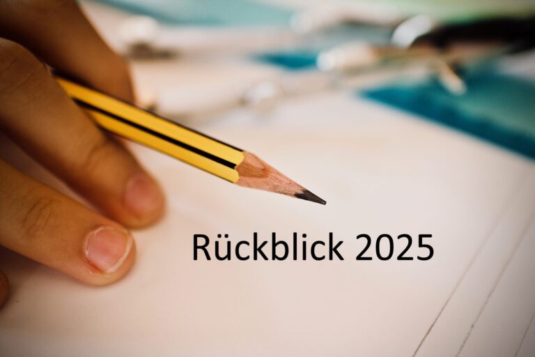 Eine Hand, die einen gelben Bleistift über ein leeres Papier hält, mit dem deutschen Text Rückblick 2025 in der Mitte. Die Zeichenwerkzeuge sind im Hintergrund verschwommen.